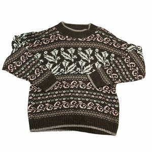 May include: A brown sweater with a white and pink floral pattern. The sweater has a crew neck and long sleeves.