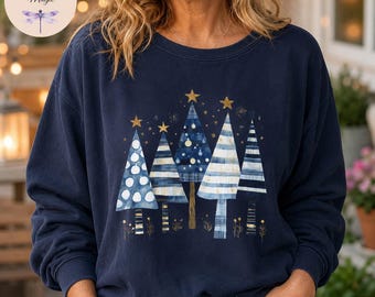 Op de afbeelding: Een marineblauw sweatshirt met ronde hals en een grafische print van vijf gestileerde kerstbomen in blauw-, wit- en goudtinten. Elke boom heeft een uniek patroon met strepen, stippen of ruiten en is bekroond met een gouden ster.