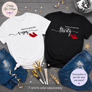 May include: A white t-shirt with the text There's no place like Vegas and a black t-shirt with the text There's no place like thirty, both featuring red glittery high heel shoes, paired with blue denim jeans and gold party horns.