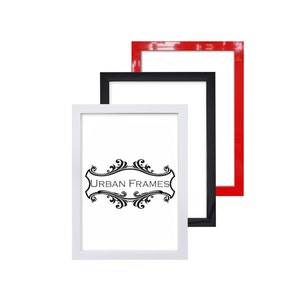 Può includere: Tre cornici per foto in bianco, nero e rosso. Le cornici sono impilate l'una sull'altra. La cornice bianca ha il testo "URBAN FRAMES" in nero.