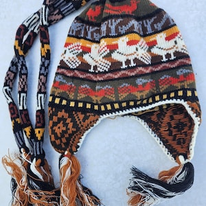May include: A colorful knitted hat with a long tassel and a geometric pattern. The hat is made of wool and has a warm, cozy feel.