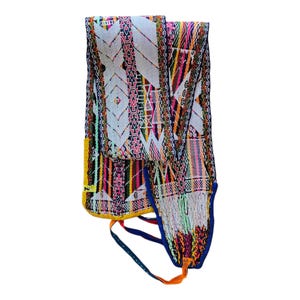 May include: A colorful woven textile with a geometric pattern. The fabric features a mix of white, pink, yellow, green, and blue hues. The textile has a fringe on the bottom and a blue and orange strap.