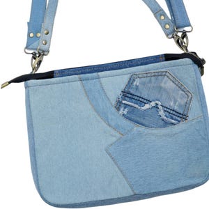Peut inclure: Sac bandoulière en jean bleu clair avec un design patchwork. Le sac comporte une petite poche, une fermeture éclair et une bandoulière amovible avec des accessoires en métal. Le sac est fait de différentes nuances de denim bleu.