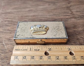 Caja de pastillas rectangular de metal con dos compartimentos, tono dorado vintage.