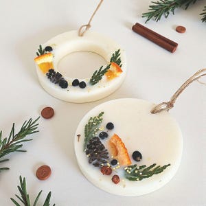 Scented wax sachets hanging on a Christmas tree, handmade soy wax ornaments with natural aroma and dried flowers.