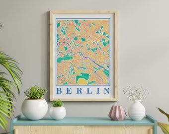 May include: A framed print of a map of Berlin, Germany. The map is in a colorful style with yellow, orange, green, and blue colors. The word "BERLIN" is printed in blue letters at the bottom of the map.