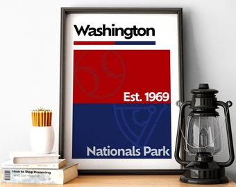 Puede incluir: Una impresión enmarcada con un diseño rojo y azul que presenta el texto "Washington", "Est. 1969" y "Nationals Park". Un gráfico de béisbol está en el centro de la impresión.