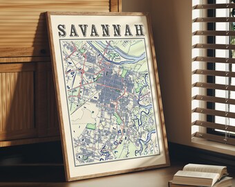 Könnte beinhalten: Eine gerahmte Karte von Savannah, Georgia, mit dem Städtenamen in fetten schwarzen Buchstaben oben. Die Karte ist in einem hellbraunen Rahmen und lehnt an einem Holzschrank.