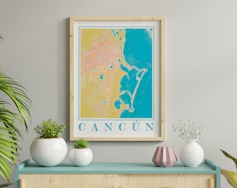 May include: A framed print of a map of Cancun, Mexico. The map is in a yellow, orange, and blue color scheme. The city name "CANCÚN" is printed in white at the bottom of the map.