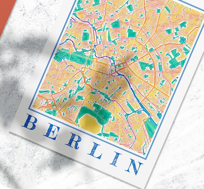 Może przedstawiać: Kolorowa mapa Berlina, Niemcy, z niebieską ramką i napisem "BERLIN" w kolorze niebieskim na dole mapy.