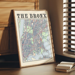 May include: A framed map of The Bronx, New York City, with a vintage style design. The map is printed on cream-colored paper with a brown frame.