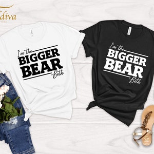 May include: Two t-shirts with the text "I'm the bigger bear - Beth" printed on them. One t-shirt is white and the other is black.