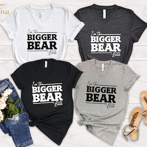 May include: Four V-neck t-shirts with the text "I'm the BIGGER BEAR -Beth" printed in black on white, black, heather gray, and dark gray shirts.