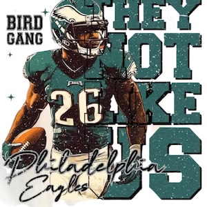 Puede incluir: Un diseño gráfico verde y negro con el texto "They Not Like Us" y "Bird Gang" y "Philadelphia Eagles" con un jugador de fútbol americano que lleva una camiseta verde y negra con el número 26.