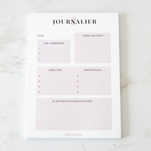 Peut inclure: Un agenda quotidien blanc avec le mot "JOURNALIER" en haut. L'agenda comporte des sections pour la date, les principales priorités, la proclamation, les objectifs, pour demain et je suis reconnaissante pour.