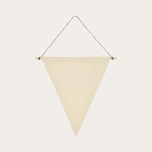 May include: A cream-coloured, triangular banner suspended from a natural wooden dowel. The banner is hung by a black and white twisted cord. The banner has a simple, minimalist design, suitable for home decor or crafting projects.