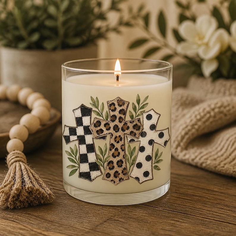 Digital sublimation instant download of A clear glass candle jar filled with white wax and a lit wick. The exterior features three cross illustrations: one with a black and white checkered pattern, one with a brown leopard print, and one with black polka dots, all accented by green leaves. PNG file transfer.
