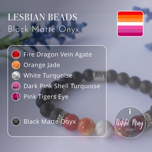 May include: A bracelet made with black matte onyx beads, fire dragon vein agate, orange jade, white turquoise, dark pink shell turquoise, and pink tiger's eye beads. The bracelet is accented with a silver charm and the text "Nikki May Studio 5/1".