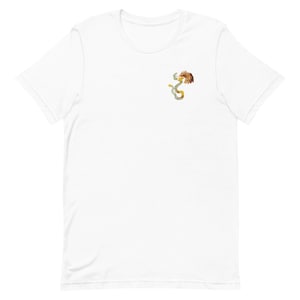 Puede incluir: Camiseta blanca con una pequeña ilustración detallada de una criatura mítica. El diseño combina elementos de una serpiente y un pájaro, con colores dorados, marrones y verdes. La camiseta está hecha de un material suave y ligero.