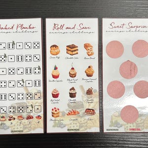 May include: Three white cards with colourful illustrations of baked goods and dice. The cards are titled "Baked Planko", "Roll and Save", and "Sweet Surprise" with the text "savings challenge" below each title. The cards are part of a savings challenge game.