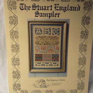 May include: A vintage sampler titled "The Stuart England Sampler" with a framed cross-stitch design. The sampler features various patterns, including letters, floral motifs, and geometric shapes. The cover has a decorative border and the text "The Nostalgic Needle".