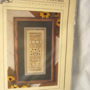 May include: A cross stitch pattern for a needlepoint project titled "Summer" by The Drawn Thread Charted Needlework Designs. The pattern features a vertical design with sunflowers, birds, and the text "For Summer's Golden Days, When All Is Bright And Gay, We Gather To Celebrate, The Joy Of Summer's Day."