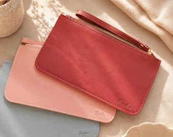 Può includere: Tre pochette rettangolari con cerniera e cinturino da polso nei colori rosso, rosa chiaro e azzurro. Ogni pochette presenta una finitura liscia e un nome impresso nell'angolo inferiore: Samtha sulla rossa, Bella sulla rosa e Joyna sull'azzurra.