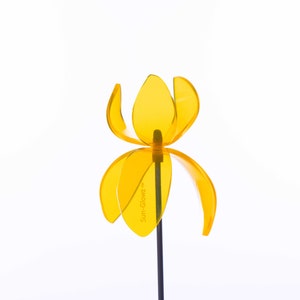 Puede incluir: Un molinillo de viento de plástico amarillo en forma de flor con el texto "Sun-Glo" en uno de los pétalos.