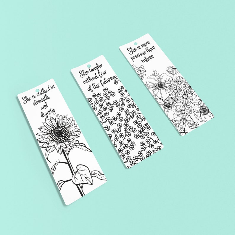 May include: Three black and white bookmark designs with inspirational quotes. The first bookmark features a sunflower and the quote "She is clothed in strength and dignity". The second bookmark features a floral pattern and the quote "She laughs without fear of the future". The third bookmark features a floral pattern and the quote "She is more precious than rubies".