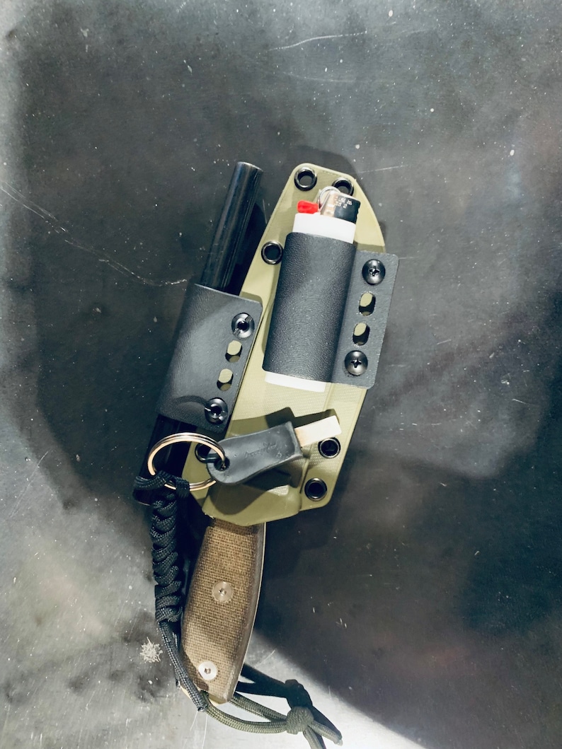 Puede incluir: Una funda de cuchillo verde con un iniciador de fuego negro, un encendedor negro y un cord&oacute;n de paracord negro.