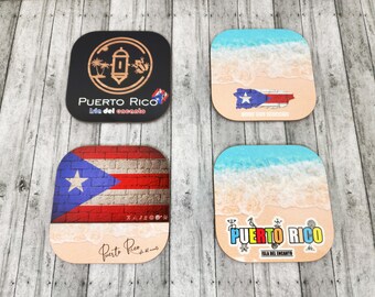 May include: Four square coasters with different designs featuring the Puerto Rican flag and the words "Puerto Rico" and "Isla del Encanto".