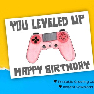 Puede incluir: Tarjeta de felicitación imprimible con un mando de videojuegos rosa y el texto "You Leveled Up Happy Birthday".