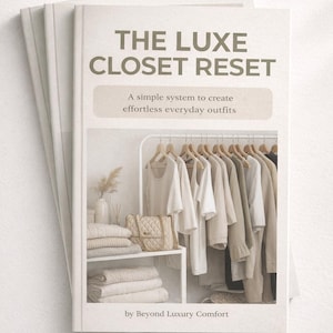 Op de afbeelding: Drie boeken getiteld "THE LUXE CLOSET RESET" met de ondertitel "A simple system to create effortless everyday outfits." De omslag toont een kast met neutrale kleding en een handtas.
