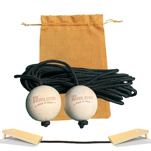 May include: Two wooden balls with "The Regulator" and "Quik Q-1955" printed on them, a black rope, and a tan drawstring bag. The balls are attached to the rope.