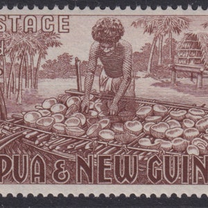 May include: A brown and white postage stamp from Papua & New Guinea showing a person preparing coconuts. The stamp features the text "POSTAGE 9d" and "PAPUA & NEW GUINEA".
