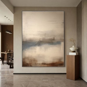 May include: Abstract painting with a muted color palette of brown, beige, and blue. The painting features a horizontal line across the center, creating a sense of depth and perspective.