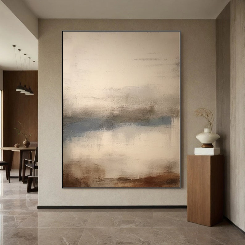 May include: Abstract painting with a muted color palette of brown, beige, and blue. The painting features a horizontal line across the center, creating a sense of depth and perspective.