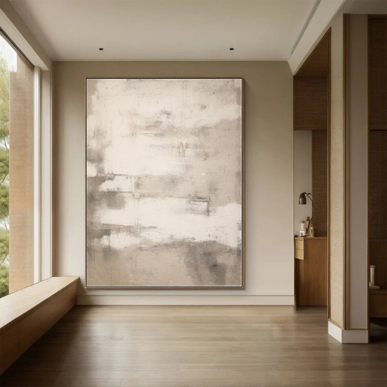 May include: Abstract painting with shades of white, gray, and beige. The painting has a textured, layered look and is displayed on a wall in a modern interior.