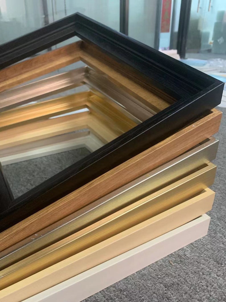 May include: A stack of picture frames in various colors and styles, including black, wood, gold, and white.