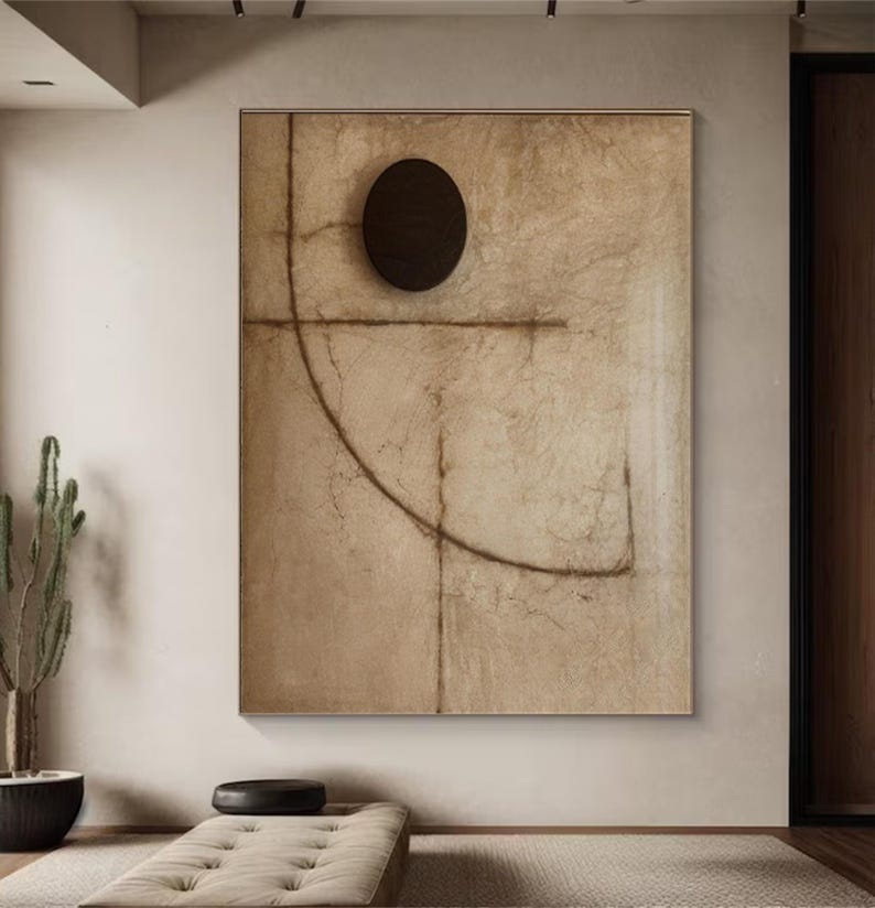 Puede incluir: Impresi&oacute;n de arte abstracto con un fondo marr&oacute;n y un c&iacute;rculo negro en el centro. La impresi&oacute;n presenta una l&iacute;nea marr&oacute;n que se curva alrededor del c&iacute;rculo y una l&iacute;nea horizontal que interseca el c&iacute;rculo.