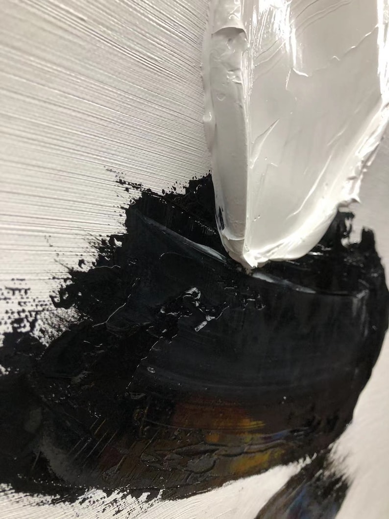 May include: Abstract painting with thick white and black paint strokes. The white paint is applied in a thick, textured layer, while the black paint is applied in a more fluid, layered style. The painting has a modern and abstract feel.