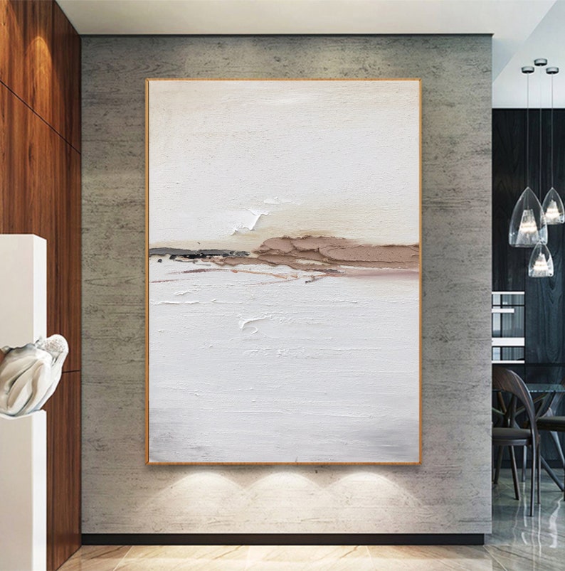 May include: Abstract painting with a white background and brown and beige accents. The painting has a textured surface and a horizontal line of brown and beige paint across the middle.