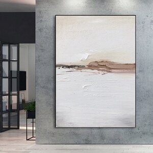 May include: Abstract painting with a white background and brown and beige accents. The painting has a textured surface and a horizontal line across the middle.