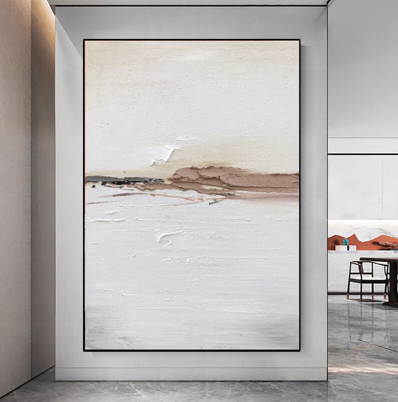 May include: Abstract painting with a white background and brown and beige accents. The painting has a textured surface and a horizontal line of brown and beige paint across the middle.
