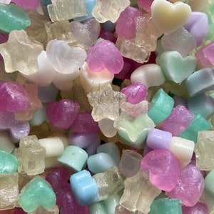 Peut inclure: Un assortiment de savons artisanaux translucides et colorés en forme de cœur, d'étoile et autres. Les savons sont fabriqués avec des ingrédients naturels et sont parfaits pour un bain ou une douche relaxante.