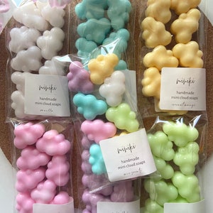 May include: Six bags of handmade mini cloud soaps in various colours and scents. The bags are labelled with the brand name "mipiki" and the scent of each soap. The scents include vanilla, coconut orange, lavender, strawberry, and peppermint.