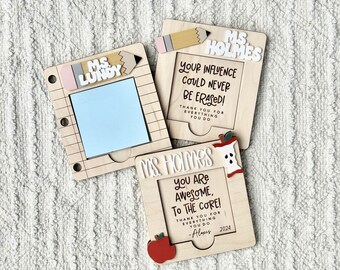 May include: Two wooden teacher appreciation plaques with a pencil and apple design. The text on the plaques reads "Ms. Lundy" and "Ms. Holmes". The plaques have a message of appreciation for the teachers.