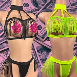 May include: Two lingerie sets on mannequins. One is black with fringe and pink accents, the other is neon green with fringe. Both sets include a halter top and a bottom with fringe.