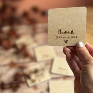 Op de afbeelding: Een vierkant houten bord met de tekst "Namur 26 Oktober 2024" en een klein hartje.