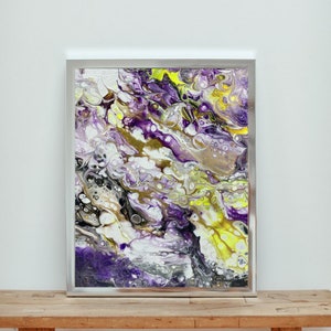 May include: Abstract painting in a silver frame with swirling purple, yellow, white, and black paint.